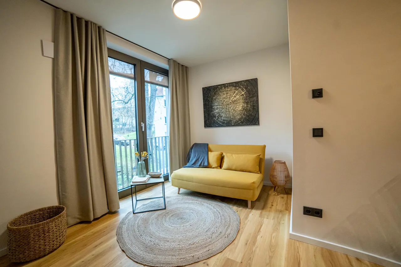 Wohnbereich mit gelbem Sessel und bodentiefem Fenster
