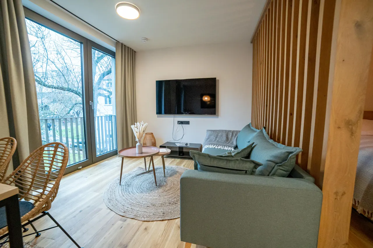 Wohnraum mit Sofa und hölzernem Raumteiler
